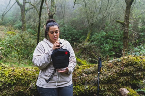 Preview: Closeup shot of the female holding a first aid bag in the forest