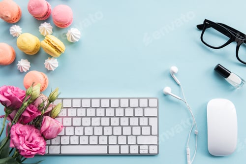Preview: top view of keyboard, macarons, eyeglasses, earphones and flowers isolated on blue