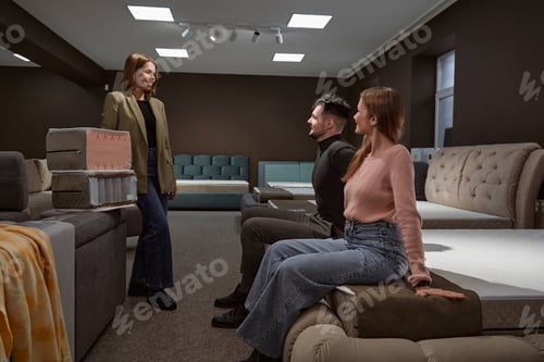 Preview: Couple of buyers testing mattress firmness in store