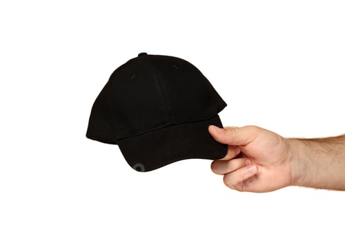 Preview: Hand presenting a black cap for casual style, on white background