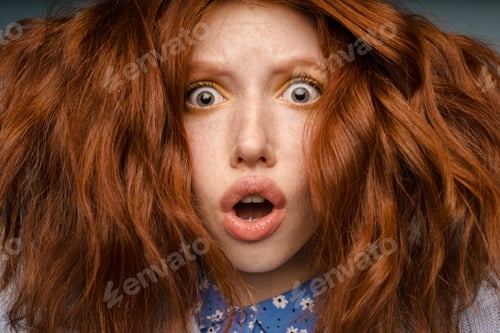 Preview: Young ginger shock woman with makeup expressing surprise at camera