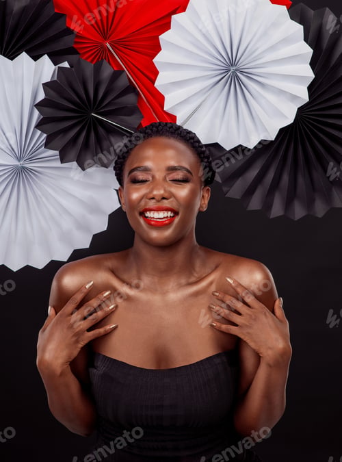 Preview: Studio shot of a beautiful young woman posing with a origami fans against a black background