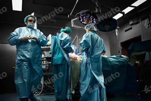 Preview: Surgical team operating on patient in theater in hospital