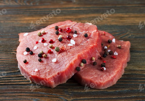 Preview: Raw beef steak with spice on brown wooden background