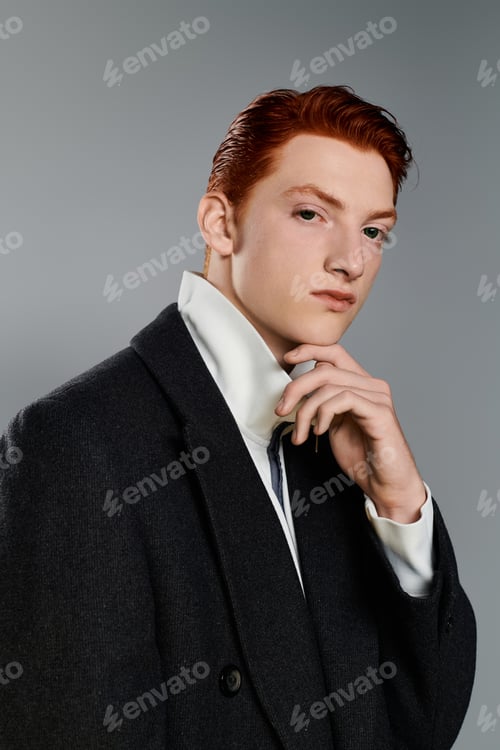 Preview: Young and stylish man in a winter coat poses confidently against a grey background