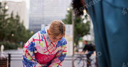Preview: Bow, respect and woman in city for welcome, greeting and tradition with kimono. Japanese people, fa