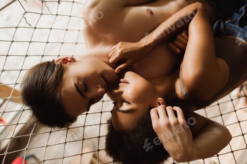 Preview: top view of shirtless man and seductive african american woman touching each other with closed eyes