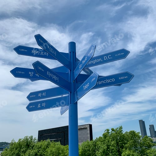 Preview: Closeup of blue direction signs, showing the direction to different cities around the world