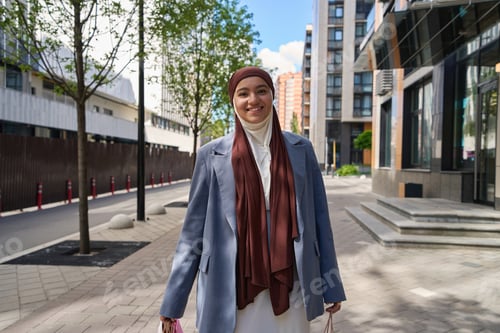 Preview: Smiling arab woman walking with shopping bags