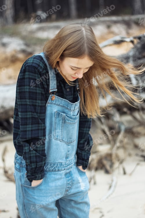 Preview: beautiful young woman walking along the seashore in autumn