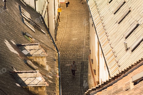Preview: Man walks on the cobbled street of the old town of Bratislava. View from above
