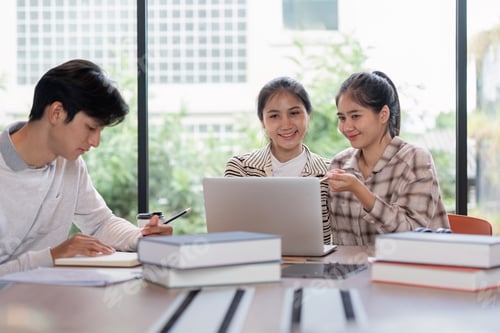 Preview: Group of Student Studying Together with Laptops and Books in a Modern Classroom Setting