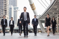 Preview: businesspeople team of multi ethnic walking with confidence in full suit