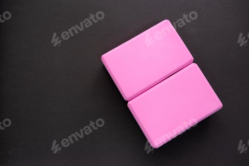 Preview: Two pink yoga blocks on a dark gray background. Top view and copy spase