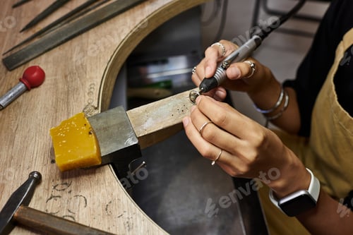 Preview: A skilled artisan delicately crafts a unique jewel at her workbench in a vibrant workshop