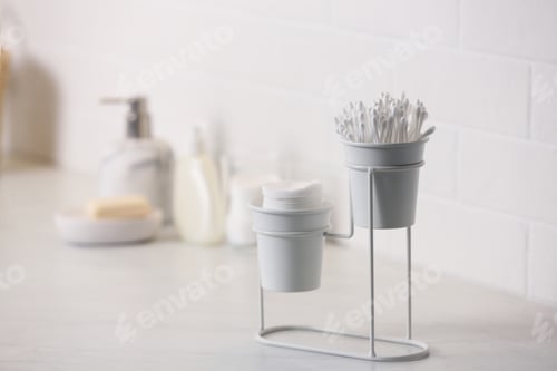 Preview: Cotton buds and pads on white table in bathroom, space for text