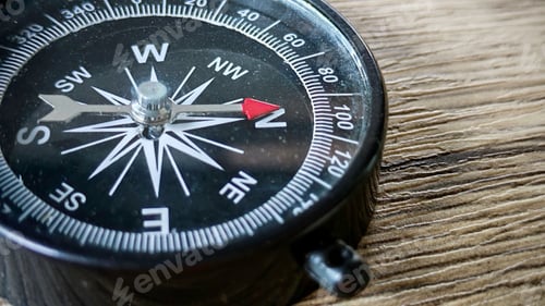 Preview: Close up of a compass on wooden surface
