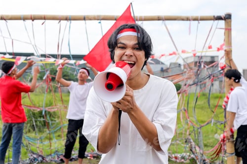 Preview: Happy Young Man With Megaphone, Celebrating National Holiday With Lively Group
