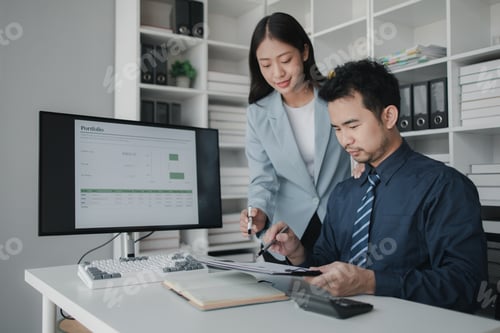 Preview: Two people looking at datasheets of marketing and sales results, analysis of business results jointl