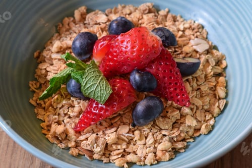Preview: Closeup bowl of breakfast granola with fresh strawberries and blueberries