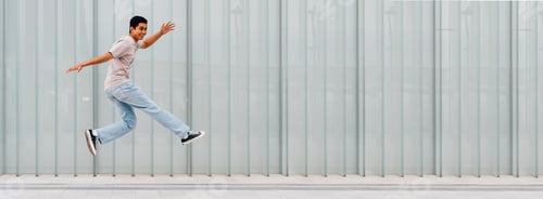 Preview: Young asian man outdoor jumping celebrating success feeling free