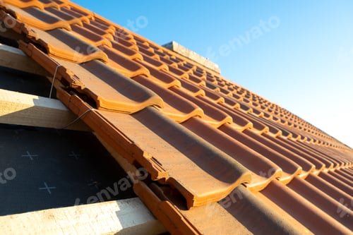 Preview: Overlapping rows of yellow ceramic roofing tiles mounted on wooden boards covering residential