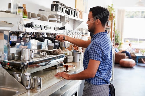 Vorschau: Junger männlicher Barista bereitet Espresso in einem Café zu