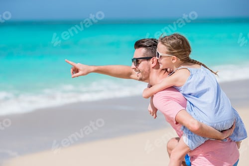 Preview: Little girl and happy dad having fun during beach vacation