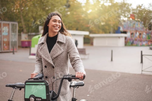 Preview: Happy brunette woman using city bike. Latin ethnicity