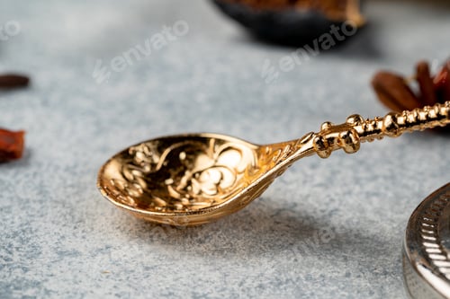 Preview: Close up of golden metal spoon on grey surface