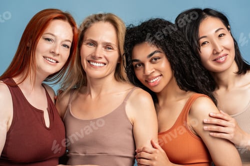 Preview: Four diverse, multinational women embracing, looking at camera, closeup posing in studio