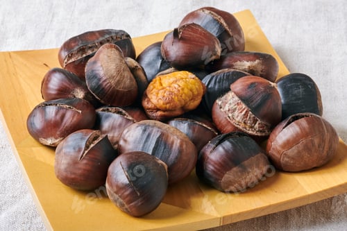 Preview: Roasted chestnuts on wooden plate
