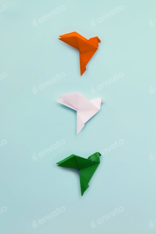 Preview: Three paper origami pigeons orange, white, and green on light blue vertical background