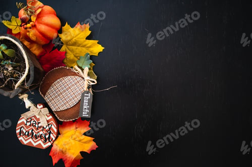 Preview: Top view of autumn maple leaves with pumpkin on a black wooden surface- thanksgiving day concept