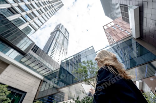 Preview: Professional woman working on her laptop in a dynamic cityscape