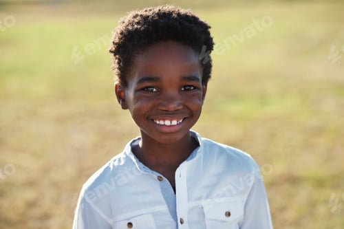 Preview: Portrait little african american boy smiling looking happy on summer day in park
