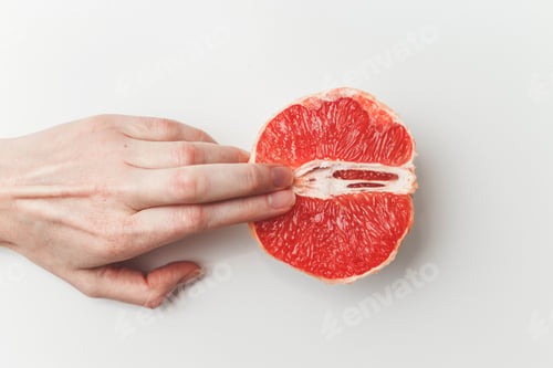 Vorschau: Sexuelles und weibliches Genitalkonzept. Grapefruit und Frauenfinger wie Vagina und Klitoris
