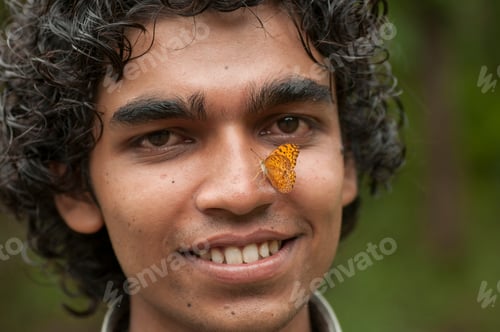 Preview: Butterfly sitting on a young man’s face, Symbiosis of man and nature.