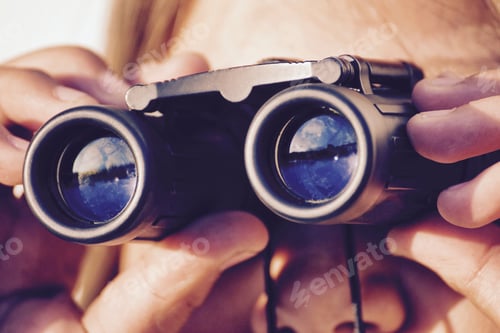 Preview: Hands Holding Binoculars Revealing Distant Views