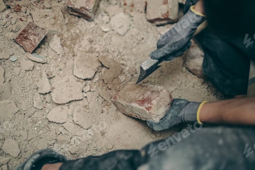 Preview: A young man cleans bricks with an axe.