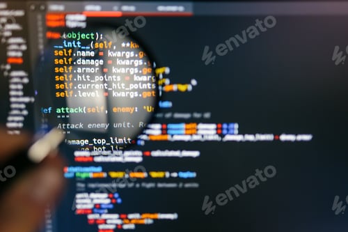 Preview: Program code on computer display in magnifying glass. Close-up