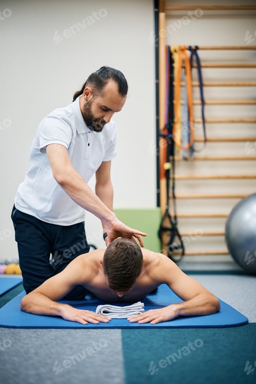 Preview: Physiotherapist massaging neck of a sportsman during the therapy at rehabilitation center.