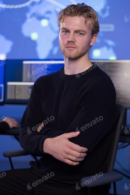 Preview: Confident cybersecurity professional in a modern SOC environment with a global map