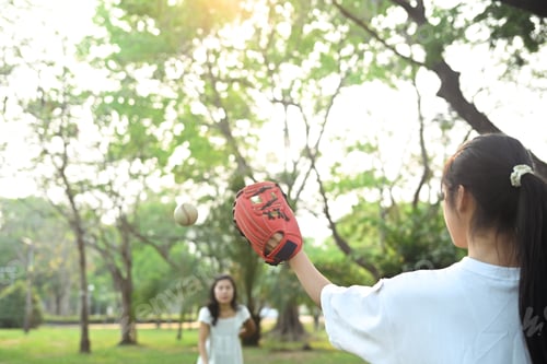 Preview: Mother and daughter playing in baseball at public park. Family, sports and leisure activity concept