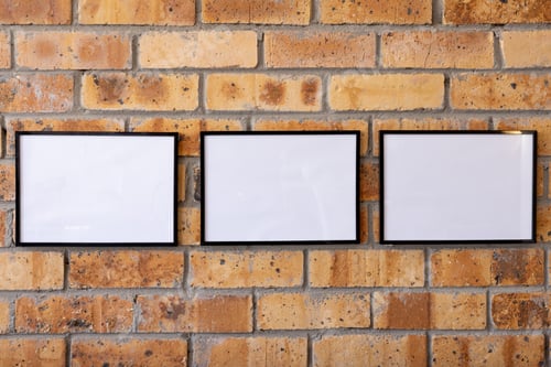 Preview: White empty frames with copy space against brick wall