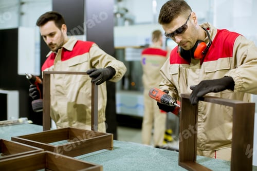 Preview: Two young workers assembling furniture in the factory