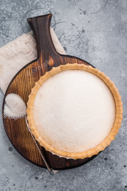 Preview: Versatile white sugar in a rustic bowl, ready to enhance desserts and beverages
