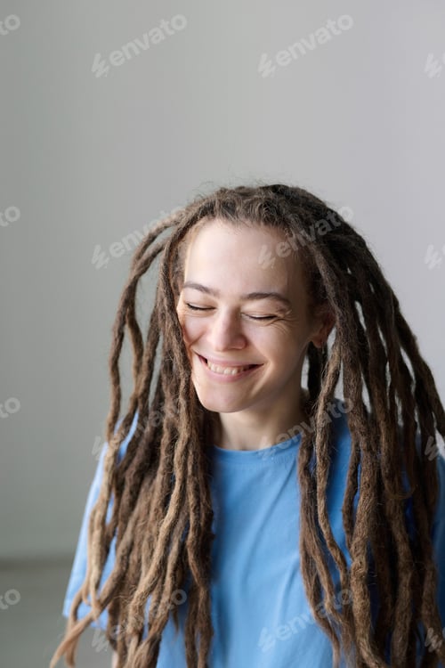 Preview: Carefree Woman with Long Dreadlocks and Eyes Closed Smiling on White