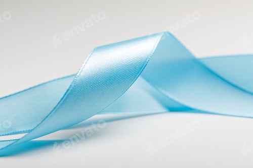 Preview: close up of curved blue silk ribbon on grey background