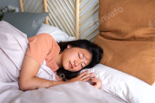 Preview: Young Asian woman sleeping in cozy bed with lots of pillows and comfortable duvet. Lifestyle.